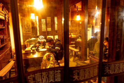 People in illuminated building at night