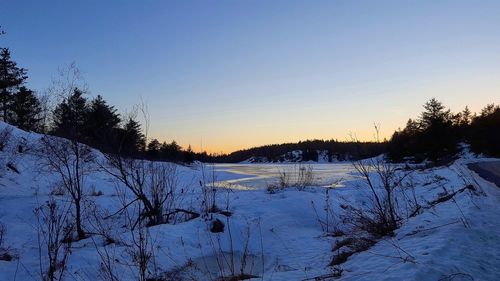 Scenic view of landscape against clear sky during winter