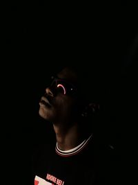 Portrait of young man against black background