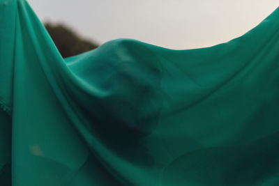Close-up of woman with face covered by green scarf