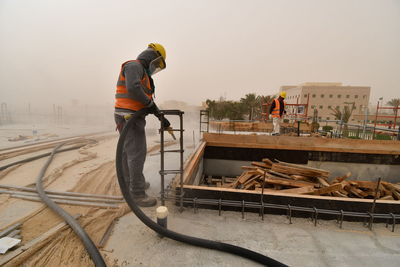 Man working at construction site against sky