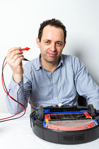 Portrait of man holding camera over black background