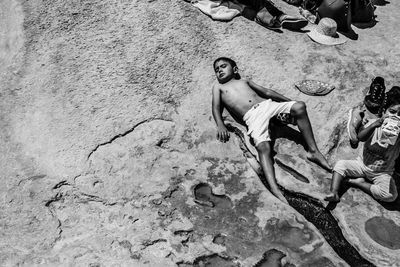 High angle view of man lying on sand