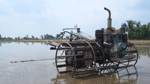 Agricultural machinery on irrigated farm against sky