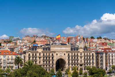 Buildings in city against blue sky