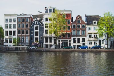 Canal by buildings in city