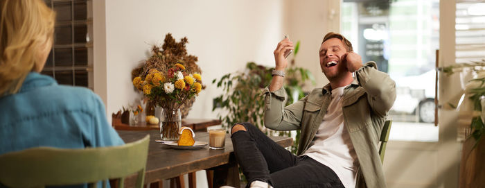 Portrait of young woman using mobile phone at home