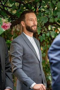 Young man standing in front of potted plants