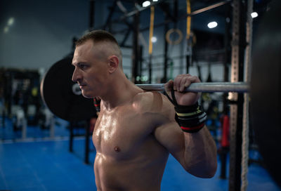 Strained sportsman exercising in gym