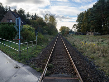 Railroad tracks amidst trees against sky