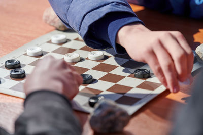 Cropped hand of man playing chess