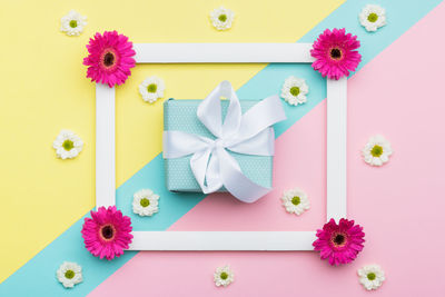 Close-up of gift and flowers on table