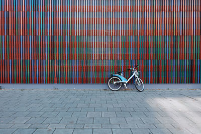 Bicycle parked against brick wall