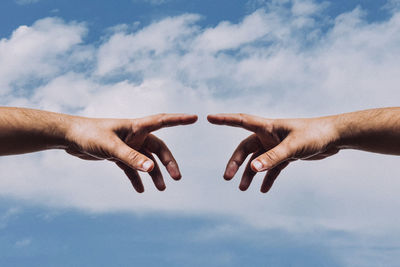 Low angle view of hand against sky