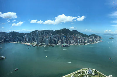 Aerial view of city by sea against sky