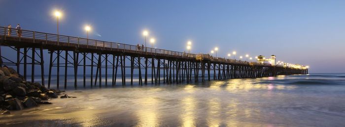 Oceanside pier at dusk. the ocean is calming and night will prevail. reflections of serenity.