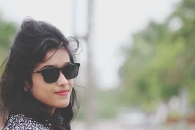 Close-up portrait of young woman wearing sunglasses