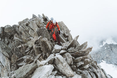 Two climbers down climbing on pinnacles on cloudy day