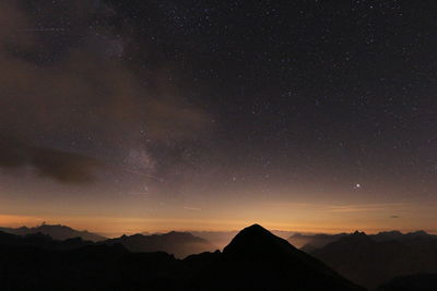 Scenic view of silhouette mountains against sky at night