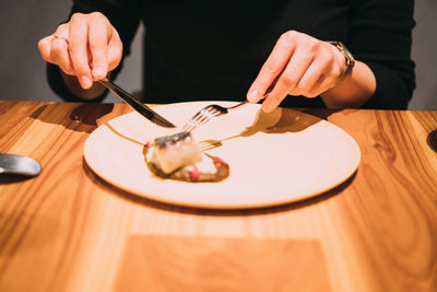 Midsection of man holding ice cream on table