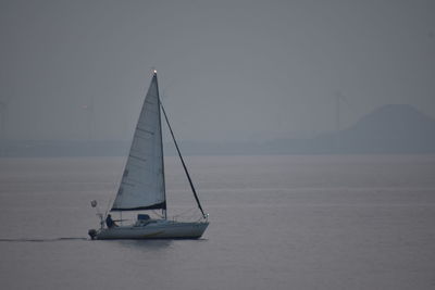 Sailboat sailing on sea against sky