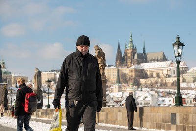 Men standing in city against sky