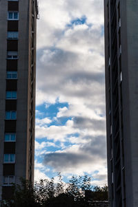 Low angle view of buildings against cloudy sky