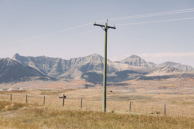 Scenic view of field by mountains against sky