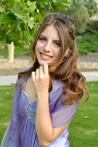 Portrait of smiling young woman standing on field