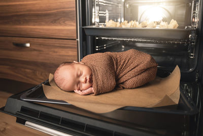 Cute baby sleeping by microwave