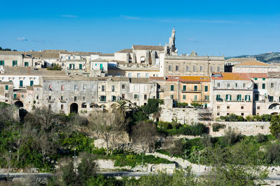 Buildings in town against blue sky