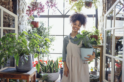 Portrait of young woman standing by window