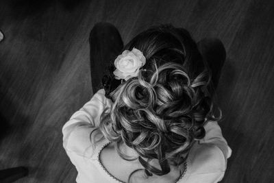 High angle view of woman with hairstyle kneeling on hardwood floor