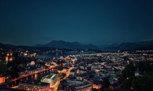 High angle view of illuminated cityscape against sky at night