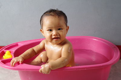 Portrait of cute baby girl taking bath at home