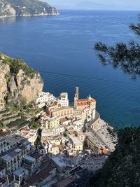 High angle view of townscape by sea against sky