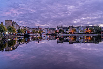 Reflection of buildings in lake against sky