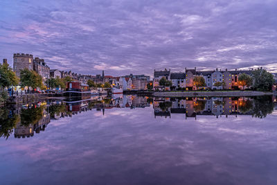 Reflection of buildings in lake against sky