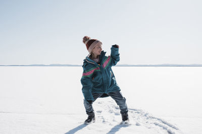 Man standing on snow covered land against sky