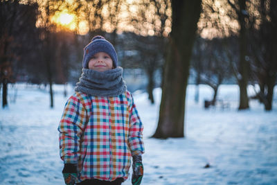 Portrait of smiling boy standing in snow