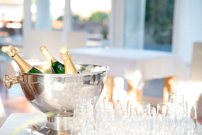Close-up of champagne flutes and bottles on table