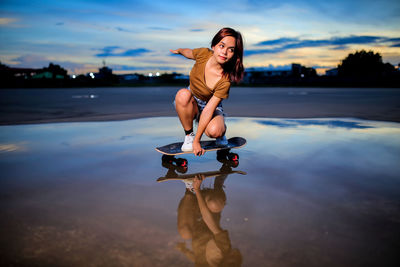 Asian women playing surf skate or skates board outdoors.