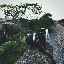 Close-up of camera against trees