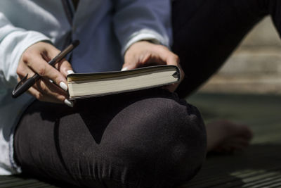 Midsection of man reading book