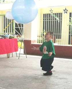 Portrait of happy boy playing with balloons