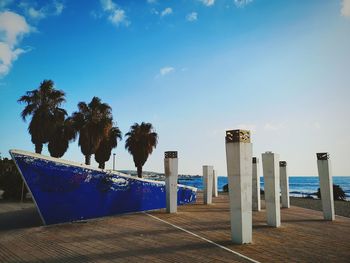 Wooden posts on beach against sky