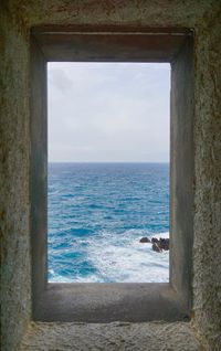 Scenic view of sea against sky seen through window