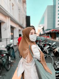 Portrait of woman with bicycle standing on street