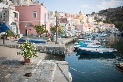 Boats moored at harbor by buildings in city