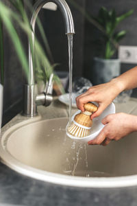 Close-up of child's hands washing dishes with eco dish brush.